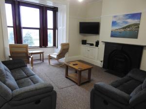 a living room with two couches and a fireplace at Hawen - Barmouth in Barmouth