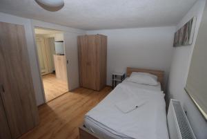 een kleine slaapkamer met een bed en een houten vloer bij AB Apartment Objekt 27 in Stuttgart