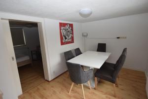 een eetkamer met een witte tafel en stoelen bij AB Apartment Objekt 27 in Stuttgart