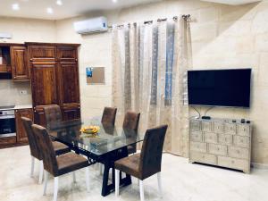 a dining room with a table and a television at Modern Maltese House in Sliema