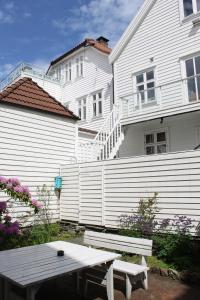 ein weißes Haus mit einer Picknickbank davor in der Unterkunft Klosterhagen Hotel in Bergen