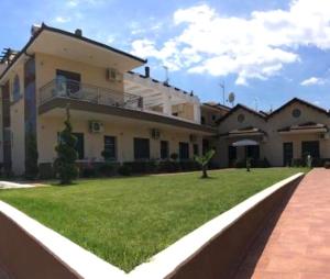a large house with a green lawn in front of it at Palmyra Studios in Stavros