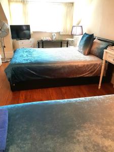 a bedroom with a large bed and a television at Gabriel Guesthouse in Rhyl