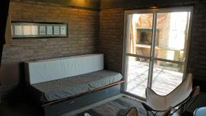 Habitación pequeña con cama y ventana en Cabaña La Miranta en Los Reartes