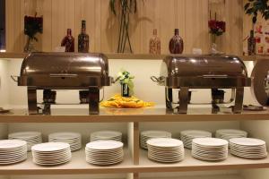 ジョホールバルにあるGrand Sentosa Hotel Johor Bahruの棚にトースターと皿が置かれたキッチン