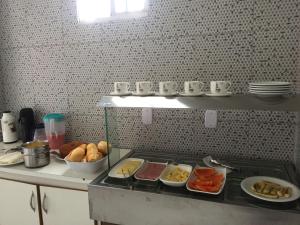 a kitchen with a counter with food on it at Alto Serra Hotel in Campina Grande