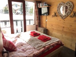 a bedroom with a bed with red pillows on it at Les Balcons de Bellevarde in Val dʼIsère