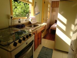 a kitchen with a sink and a stove and a window at Casa do Artista in Lumiar
