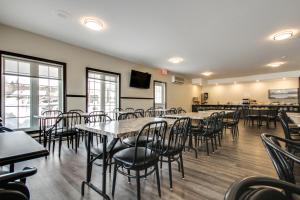 a restaurant with tables and chairs in a room at Hôtel Marineau Shawinigan in Shawinigan