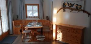a dining room with a wooden table and a window at Chasa Melchior in Zernez