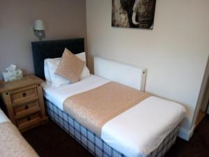 a bedroom with a bed and a dresser at The Waverley Inn in Dingwall