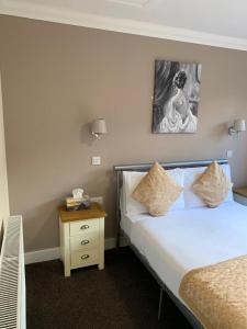 a bedroom with a bed, a desk and a painting on the wall at The Waverley Inn in Dingwall