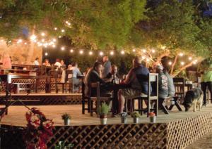 eine Gruppe von Menschen, die an einem Tisch auf einem Deck sitzen in der Unterkunft En'kanto Valle de Guadalupe in San Marcos