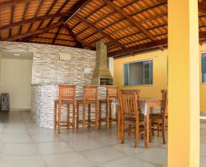 comedor con mesa, sillas y chimenea en Pouso Oliveira Casa com ar condicionado en São João Batista do Glória