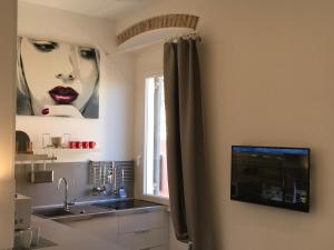 kuchnia ze zlewem, okno i telewizor w obiekcie Klee House Trastevere w Rzymie