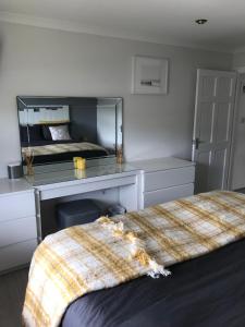 a bedroom with a bed and a desk with a mirror at Beachy in Newquay