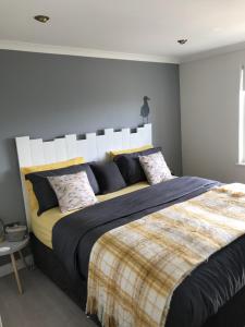 a bedroom with a large bed with a white headboard at Beachy in Newquay