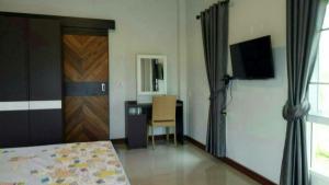 a room with a bed and a door and a desk at Ban Thung Talay Mok Chiangdao in Chiang Dao