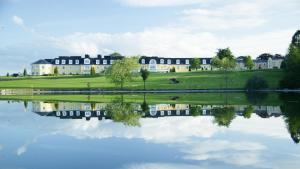a large house with a reflection in a lake at Mount Wolseley Holiday Home - Privately Owned in Tullow