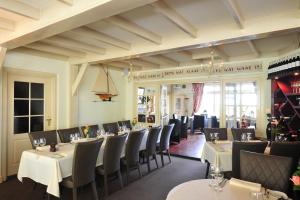 a dining room with white tables and chairs at 't Streefkerkse Huis in Zoutelande