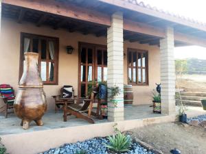 En'kanto Valle de Guadalupe في San Marcos: منزل به مزهرية كبيرة يجلس خارجه
