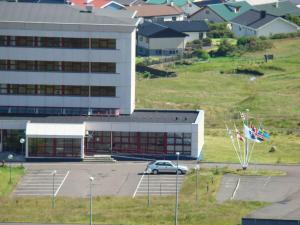 a car parked in a parking lot in front of a building at 62N Guesthouse Marknagil in Tórshavn