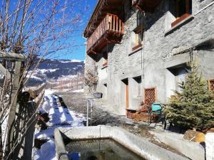 una casa en la nieve con un árbol de Navidad al lado en Les Balcons du Molliebon, en Séez