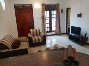 a living room with two chairs and a television at Ice Berg in Mount Lavinia