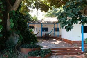 ein Haus mit einer Terrasse mit einem Tisch und Stühlen in der Unterkunft Finca del Rio Palomino in Palomino