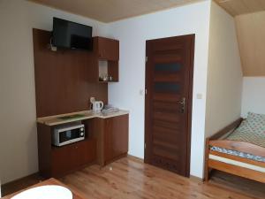 Krajno PierwszeにあるNoclegi Na Wzgórzuの小さなキッチン、ベッドが備わる小さな客室です。