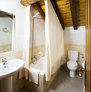a bathroom with a tub and a toilet and a sink at Apartamentos Casa Buisan in Broto