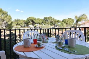 - une table blanche avec des chaises et des tasses sur le balcon dans l'établissement Center Beach, à Marina di Ragusa