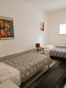 1 dormitorio con 2 camas y mesa con lámpara en Apartman Unka, en Metković