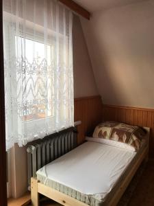 a small bed in a room with a window at Pokoje Gościnne in Bukowina Tatrzańska