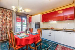 een keuken met een tafel met een rode tafellaken bij Apartment Infinity in Rijeka