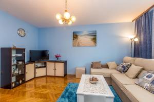 a living room with a couch and a tv at Apartment Infinity in Rijeka