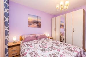 sypialnia z dużym łóżkiem i fioletowymi ścianami w obiekcie Apartment Infinity w mieście Rijeka