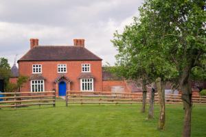 una gran casa de ladrillo rojo con puerta azul en Huntlands Farm Bed & Breakfast en Bromyard