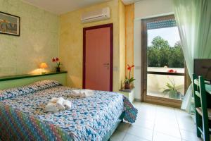 un dormitorio con una cama con dos animales de peluche en Hotel S'Ustiarvu, en Cala Liberotto