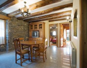 a dining room with a wooden table and chairs at Apartamentos Casa Buisan in Broto