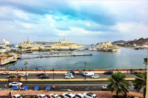 un port avec des navires de croisière dans une grande étendue d'eau dans l'établissement NASEEM HOTEL, à Mascate