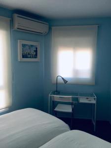 1 dormitorio con 1 cama y escritorio con lámpara en Apartamento Cantabrico, en Cádiz