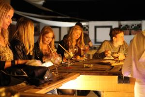 un grupo de personas sentadas en una mesa con copas de vino en Columbus Rooftop Hostel, en Las Palmas de Gran Canaria