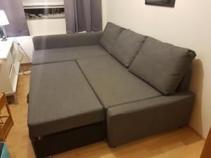um sofá cinzento numa sala de estar em Hvammur 2 Bjarg with private hot tub em Drangsnes
