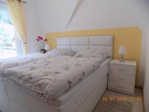 a bedroom with a white bed and a window at Urlaubstraum in Trassenheide