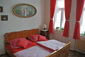 sypialnia z łóżkiem z czerwonymi poduszkami w obiekcie Restaurace a penzion Ubrousku prostři se w mieście Nová Bystřice