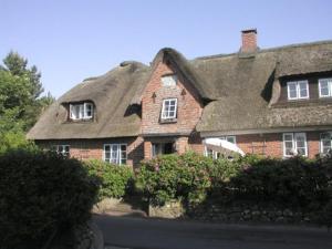 a large brick house with a thatched roof at Deichblick in Utersum