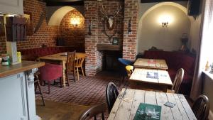 a restaurant with tables and chairs and a fireplace at The Swan Inn in Hilborough
