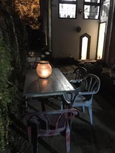a table and chairs with a vase on top of it at Passpartout Hostel in Timişoara