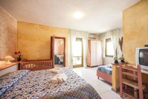 una camera d'albergo con due letti e una televisione di Hotel S'Ustiarvu a Cala Liberotto